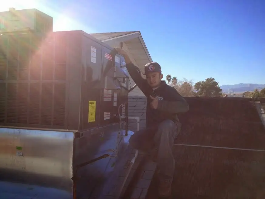 HVAC technician performing Heat Pump Repair on a rooftop unit in Oradell